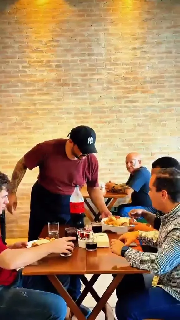 Clientes à mesa e atendimento no salão acolhedor do Quintal da Irene